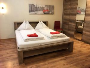 Una cama con dos almohadas rojas encima. en Interlaken Linda Inn Lodge en Interlaken