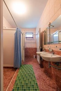 a bathroom with a shower and a sink and a mirror at CycloCamp & Hostel in Skorenovac