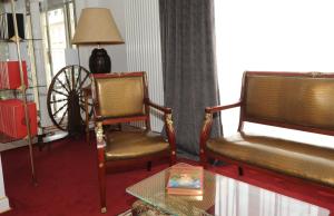 a living room with two chairs and a table at Hôtel Victor Hugo in Pontorson