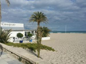 a palm tree on the beach next to a building at Parkview near beach in Alicante