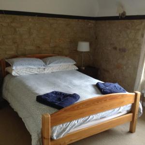 una cama con dos toallas azules sentadas en ella en Ockhams Farm Guest House en Edenbridge