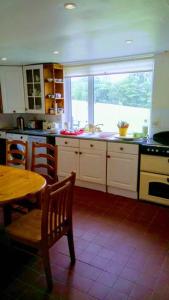 a kitchen with a table and a table and a window at Ockhams Farm Guest House in Edenbridge