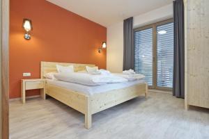 a bedroom with a large bed with an orange wall at Apartmány Terasy Café in Liberec