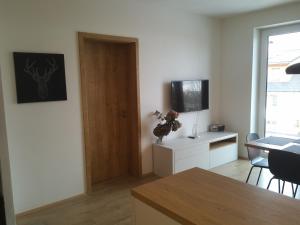a living room with a door and a table and chairs at Apartmány Sport Dolní Morava in Dolní Morava