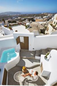 een vrouw op een tafel op het balkon van een huis bij The Small Architect's House in Pirgos