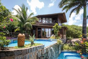 a villa with a swimming pool and a house at Sombra e Água Fresca Resort in Pipa