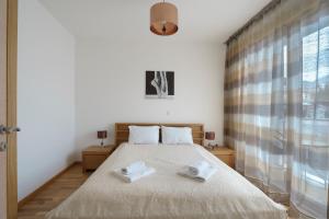 a bedroom with a bed with two towels on it at Apartments LORA Bokeljske brigade in Budva