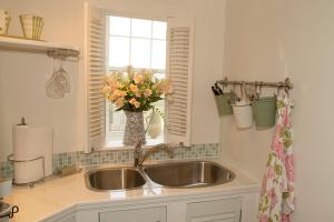 a kitchen sink with a vase of flowers in a window at Star of the Sea B&B in Halifax