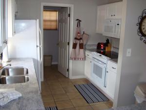 a kitchen with white cabinets and a sink at Grant's Condo in The Greens in Branson