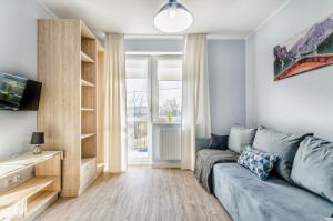 salon z kanapą i oknem w obiekcie Apartamenty Novomiejska 17 w mieście Lublin