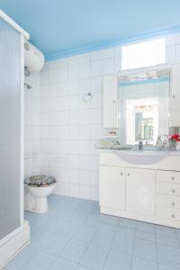 a white bathroom with a sink and a toilet at Villa Valia in Skala Kallirakhis