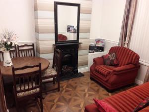 een woonkamer met een stoel, een bank en een spiegel bij Titanic Sailortown Belfast City Centre townhouse in Belfast