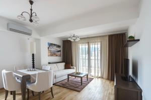 uma sala de estar com um sofá branco e uma mesa em Apartments LORA Jadranskij put em Budva