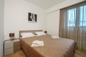 um quarto com uma cama com duas toalhas em Apartments LORA Jadranskij put em Budva