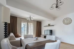 uma sala de estar branca com uma mesa e um sofá em Apartments LORA Jadranskij put em Budva
