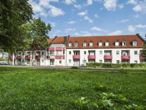 a large white building with a red roof at Andante Hotel Erding in Erding