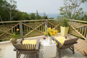 a balcony with chairs and a table with flowers on it at Star of the Sea B&B in Halifax