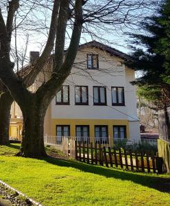 uma casa branca com uma cerca e uma árvore em Mundaka Sea Flat em Mundaka