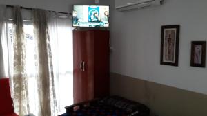 een woonkamer met een tv en een raam bij Alojamiento Cba Observatorio in Cordoba