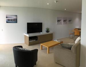 a living room filled with furniture and a tv at Wallaroo Marina Waterfront Luxe Apartment in Wallaroo