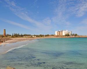 a beach with a large body of water at Wallaroo Marina Waterfront Luxe Apartment in Wallaroo