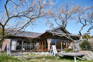 ein Haus mit einem Baum davor in der Unterkunft HOTEL MYTH M -ホテル マイス エム- Adult Only in Sennan