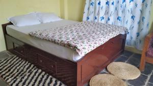 a bed with a wooden frame in a room at Hotel Sanskaar in Bandīpur