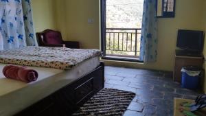 バンディプールにあるHotel Sanskaarのベッドルーム1室(ベッド1台、椅子、窓付)