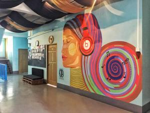 a wall with a painting of a woman with a target at Song of Travel Hostel in Nyaungshwe Township