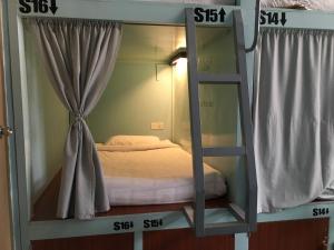 a bunk bed in a room with two windows at Song of Travel Hostel in Nyaungshwe Township