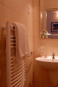 W łazience znajduje się umywalka i biały ręcznik. w obiekcie Budapest Museum Central w Budapeszcie