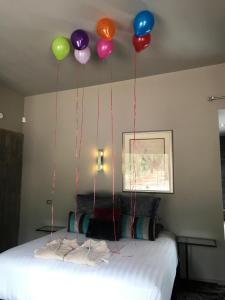 a bunch of balloons are hanging above a bed at Spa Suites at RAVEN in Hepburn Springs