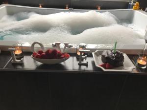 a bath tub with two desserts in front of a jacuzzi tubastery at Spa Suites at RAVEN in Hepburn Springs