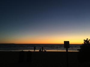 帕克德爾的住宿－柏岱爾汽車旅館，一群人日落时在海滩上散步