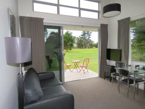 ein Wohnzimmer mit einem Sofa und einem Tisch in der Unterkunft The Links Carters Beach Apartments in Carters Beach