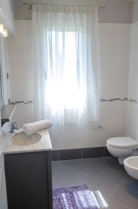 a bathroom with a sink and a toilet and a window at Alloggi Agrituristici Le Vignole in Cordignano