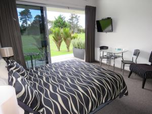 um quarto com uma cama com estampa de zebra e uma televisão em The Links Carters Beach Apartments em Carters Beach