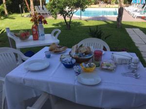 una mesa blanca con platos de comida. en B&B Villa Elena, en Furci Siculo