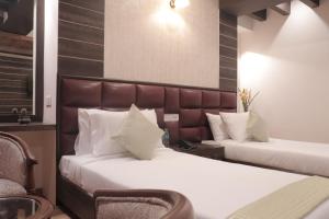 Jai Hotels tesisinde bir odada yatak veya yataklar
