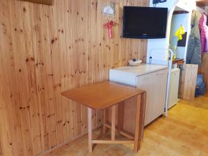 a kitchen with a table and a tv on a wall at monolocale paradiso aremogna in Roccaraso