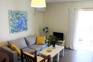 Apartment SEA VIEW in front of the beach of Agia Marina في بورتو رافتي: غرفة معيشة مع أريكة وطاولة