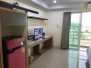 a room with a desk with a television and a window at AP Grand Residence in Rayong
