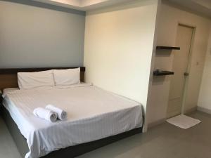 a bedroom with a bed with two rolls of toilet paper on it at AP Grand Residence in Rayong