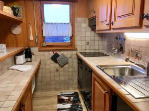 eine kleine Küche mit einem Waschbecken und einem Fenster in der Unterkunft Corbassière 32 in Verbier