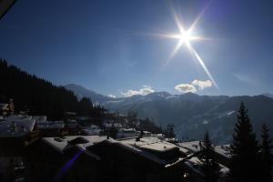 Eine Sonne, die am Himmel über einer Stadt scheint in der Unterkunft Corbassière 32 in Verbier