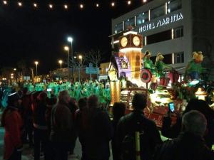 Une foule de gens qui regardent une parade la nuit dans l'établissement Hotel Marina, à Roses