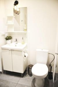 a white bathroom with a toilet and a sink at Apartament 100m od morza in Sopot +29 photos