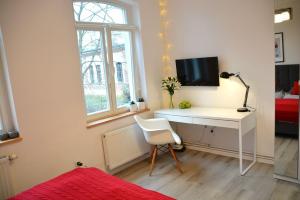 a bedroom with a desk with a computer and a bed at Apartament 100m od morza in Sopot