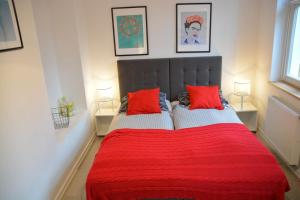 a bedroom with a red bed with two red pillows at Apartament 100m od morza in Sopot