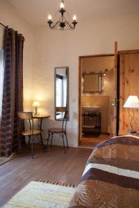1 dormitorio con cama, mesa y espejo en Algallika Guesthouse, en Kukeranna